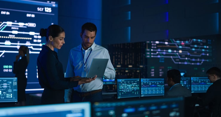 Two people working at computers in a modern office